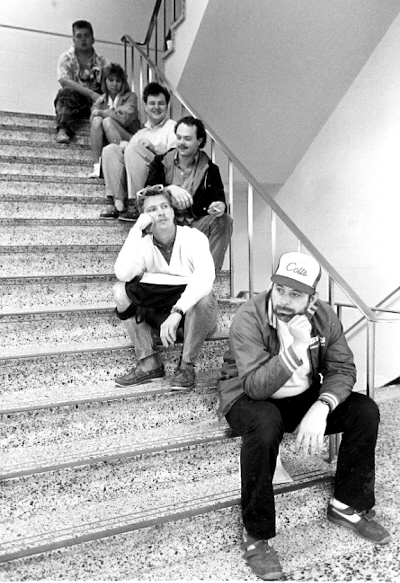 Six people sitting on a staircase, putting on a dissaffected aire